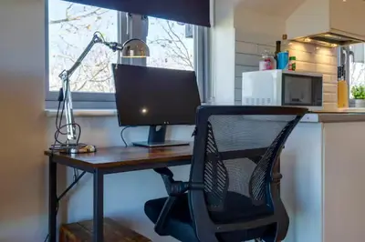 a desk with a computer monitor and a chair at Stylish and Modern Flat with Free Parking - Pass the Keys in Cambridge