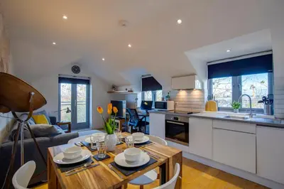 a kitchen and living room with a table and chairs at Stylish and Modern Flat with Free Parking - Pass the Keys in Cambridge