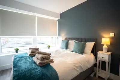 a bedroom with a bed with towels on it at Harlow Flat - Perfect for Families or Contractors in Harlow