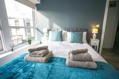 a bedroom with a large bed with pillows on it at Harlow Flat - Perfect for Families or Contractors in Harlow