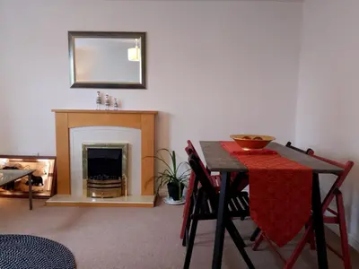 a dining room with a table and a fireplace at 2 Bed - Sleeps 4 - Free Parking in Ely