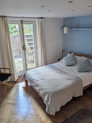 a bedroom with a bed and a large window at Beautiful apartment in central Cambridge in Cambridge