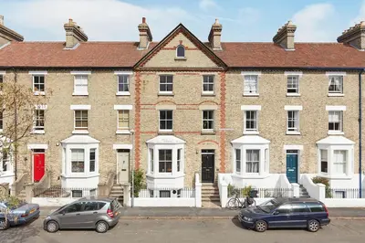 a large brick building with cars parked in front of it at Beautiful apartment in central Cambridge in Cambridge