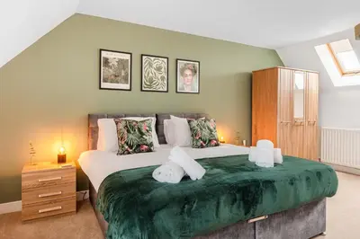 a bedroom with a large bed with two towels on it at 4 Bed, 3 Bath Townhouse in Colchester - Business, Contractor and Leisure - Singles or Superkings - Disc0unts in Lexden