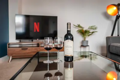 a bottle of wine sitting on a table with two wine glasses at 4 Bed, 3 Bath Townhouse in Colchester - Business, Contractor and Leisure - Singles or Superkings - Disc0unts in Lexden