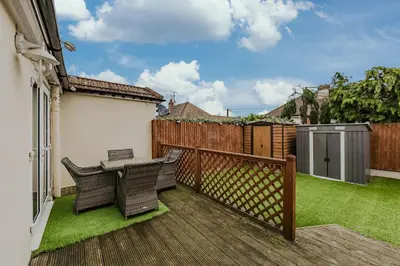 a balcony with two chairs and a table and a fence at New 4BR Gem, Central, 3 Car Drive, Contractor Stay in South Benfleet