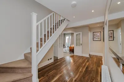 a white staircase in a home with wooden floors at New 4BR Gem, Central, 3 Car Drive, Contractor Stay in South Benfleet