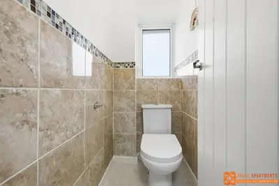 a bathroom with a toilet and a shower with a window at 4 Bed, 2 Bath Detached House, Parking, Fast Wifi in Colchester