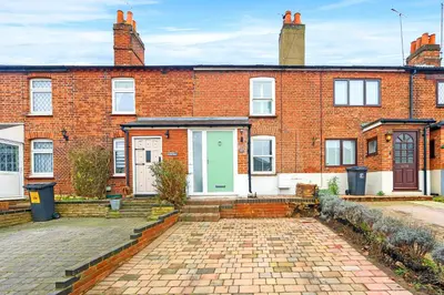 an old brick house with a green door at Modern cottage! 5 mins from central line! in Theydon Bois
