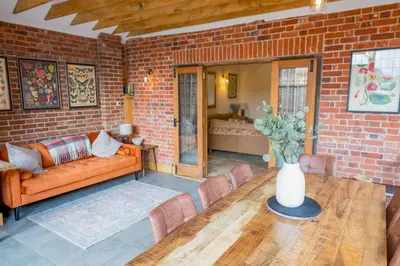 a living room with a couch and a brick wall at An elegant countryside hideaway with four indulgent ensuite bedrooms in Fressingfield