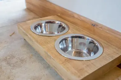 two metal dog bowls sitting on a wooden platform at An elegant countryside hideaway with four indulgent ensuite bedrooms in Fressingfield