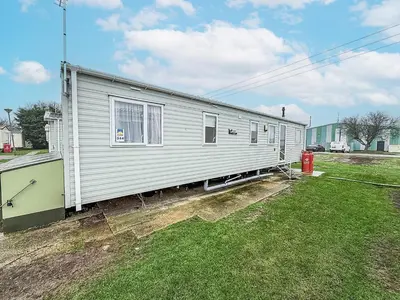 a house that is sitting on top of a yard at Seawick, 4 Bed, 10 Berth Caravan With Central Lounge, Dg & Ch Opal Rated in Clacton-on-Sea
