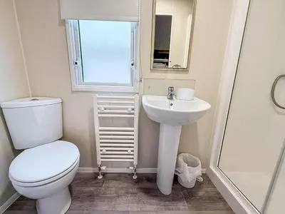 a small bathroom with a toilet and a sink at Seawick, 4 Bed, 10 Berth Caravan With Central Lounge, Dg & Ch Opal Rated in Clacton-on-Sea