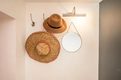 two hats are hanging on a wall at Pink Cottage in Leiston