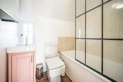 a bathroom with a toilet and a sink and a tub at Pink Cottage in Leiston