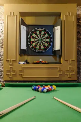 a dart board with balls on a pool table at Luxury Rock & Roll Suite in Manor House in Saffron Walden