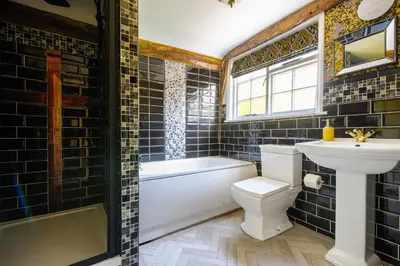 a bathroom with a sink and a toilet and a tub at Luxury Rock & Roll Suite in Manor House in Saffron Walden