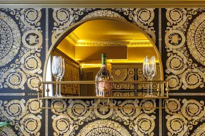 a mirror on a wall with a bottle and glasses on a shelf at Luxury Rock & Roll Suite in Manor House in Saffron Walden