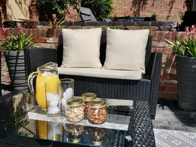 a black wicker chair with a glass table with a drink at Luxury Rock & Roll Suite in Manor House in Saffron Walden