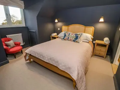 a bedroom with a bed and a red chair at 52 Lee Road in Aldeburgh