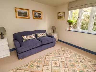 a living room with a purple couch and a rug at 52 Lee Road in Aldeburgh