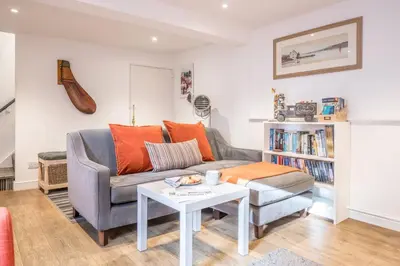a living room with a couch and a table at The Secret Cottage, Aldeburgh in Aldeburgh