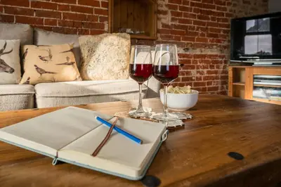 two glasses of wine sitting on a wooden table at The Knoll, Alderton in Alderton