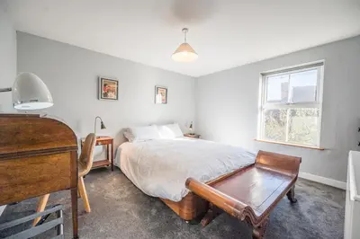 a bedroom with a bed and a desk and a piano at The Knoll, Alderton in Alderton