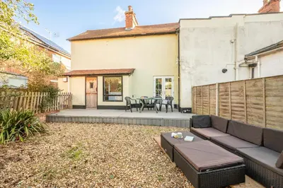 a backyard with a couch and a table at The Knoll, Alderton in Alderton