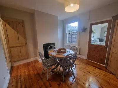 a dining room with a table and chairs and a fireplace at Central Cambridge -comfortable Victorian Terrace in Cambridge