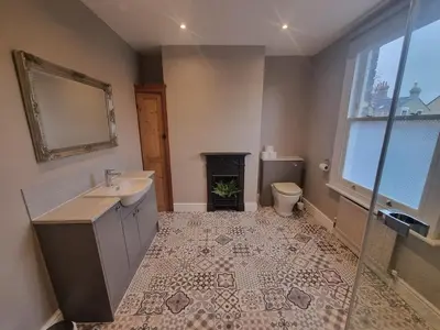 a bathroom with a sink and a toilet and a fireplace at Central Cambridge -comfortable Victorian Terrace in Cambridge