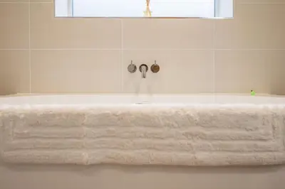 a white bath tub with a white towel on it at 100 Leiston Road, Aldeburgh in Aldeburgh