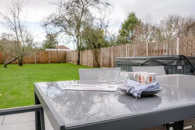 a table with a laptop and glasses on it at 100 Leiston Road, Aldeburgh in Aldeburgh