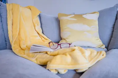 a pair of glasses and a blanket on a couch at 100 Leiston Road, Aldeburgh in Aldeburgh