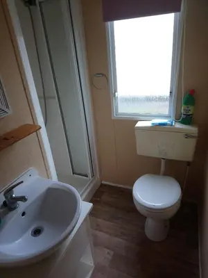 a bathroom with a toilet and a sink and a window at The Franklin in Saint Osyth