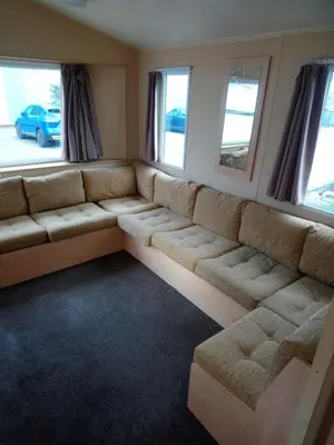a large couch in a room with windows at The Franklin in Saint Osyth