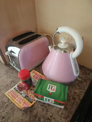 a pink tea kettle on a counter next to a toaster at The Franklin in Saint Osyth