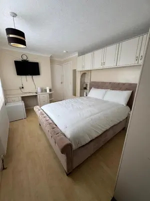 a bedroom with a large bed and a desk at Hawkins Guesthouse in Milton