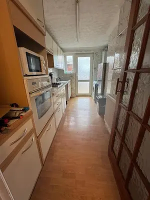 a kitchen with white appliances and a wooden floor at Hawkins Guesthouse in Milton
