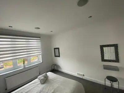 a white bedroom with a bed and a window at Cozy Town Centre 2 Bed Apartment Close To Historic Landmarks And Great Restaurants in Ipswich