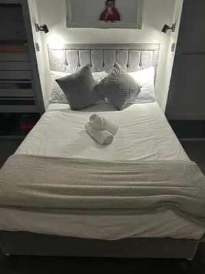 a white bed with two towels on top of it at Cozy Town Centre 2 Bed Apartment Close To Historic Landmarks And Great Restaurants in Ipswich
