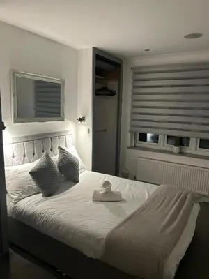 a bedroom with a white bed with a hat on it at Cozy Town Centre 2 Bed Apartment Close To Historic Landmarks And Great Restaurants in Ipswich