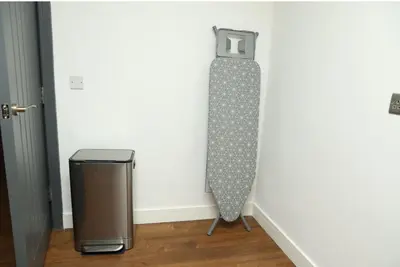 a snowboard leaning against a wall next to a trash can at Modern 2 Bed 2 Bath Apartment In Colchester, Walk To Town Center & Station in Colchester