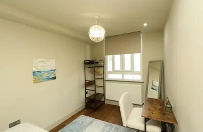 a living room with a table and a chair at Modern 2 Bed 2 Bath Apartment In Colchester, Walk To Town Center & Station in Colchester
