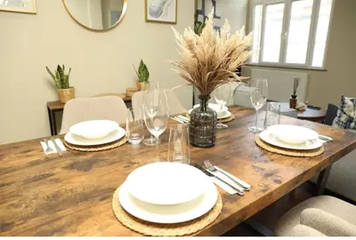 a wooden table with white plates and glasses on it at Modern 2 Bed 2 Bath Apartment In Colchester, Walk To Town Center & Station in Colchester