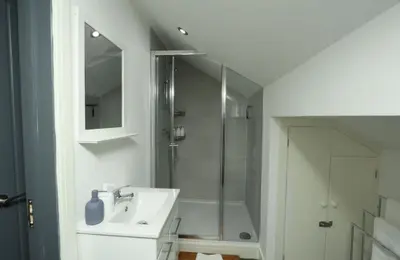 a white bathroom with a shower and a sink at Modern 2 Bed 2 Bath Apartment In Colchester, Walk To Town Center & Station in Colchester