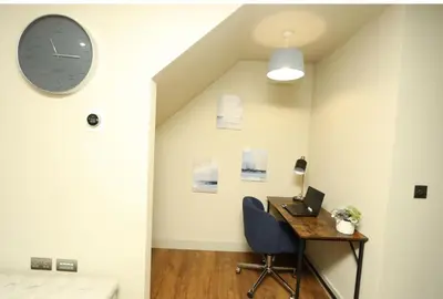 a room with a desk and a clock on the wall at Modern 2 Bed 2 Bath Apartment In Colchester, Walk To Town Center & Station in Colchester