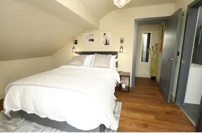 a bedroom with a large bed with white sheets at Modern 2 Bed 2 Bath Apartment In Colchester, Walk To Town Center & Station in Colchester