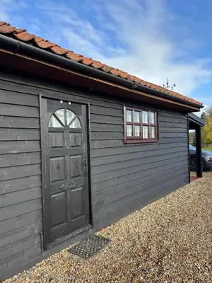 a garage with a door and a window and a car at Poets View - Studio in Honington, Suffolk in Honington