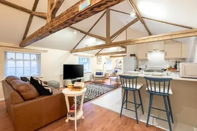 a living room with a couch and a table with stools at 1 Bed in Scole oc-a34355 in Scole